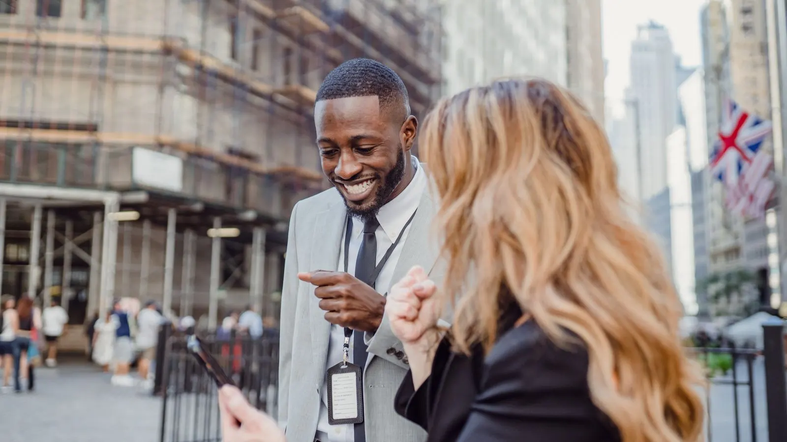Two people in conversation on a London street with red brick buildings behind
